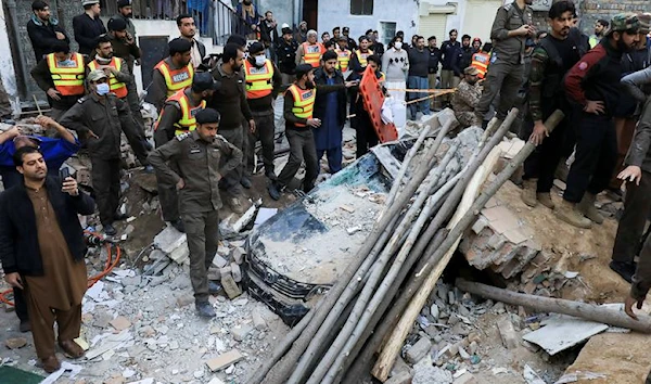 People and rescue workers gather amid the damages after a suicide blast in a mosque in Peshawar, Pakistan, January 30, 2023 (Reuters).