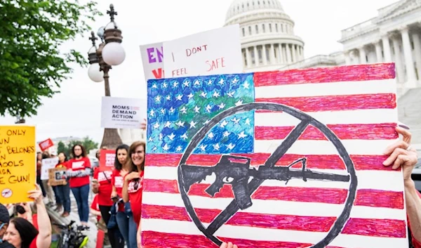 Demonstrators hold signs during a rally with senators outside the US Capitol to demand the Senate take action on gun safety on May 26, in Texas. (Getty Images)