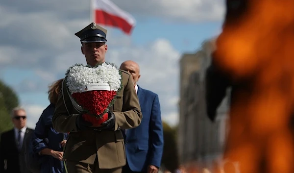 A Polish soldier holds a wreath while attending a ceremony marking national observances of the anniversary of Second World War in Warsaw, Poland, Sept. 1, 2022. (AP Photo/Michal Dyjuk)