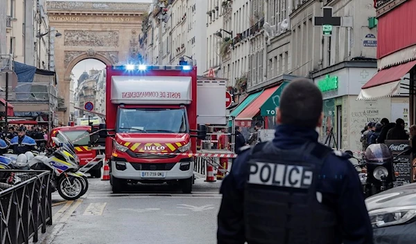 A police officer stands next to the cordoned-off area where a shooting took place in Paris on Friday. (AP)