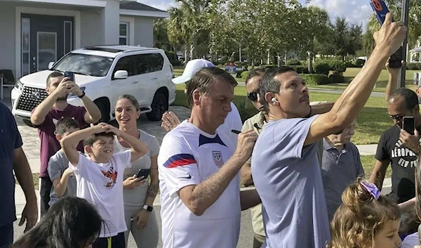 Former Brazil President Jair Bolsonaro, center, meets with supporters outside a vacation home where he is staying near Orlando, Fla., on Wednesday, Jan. 4, 2023 (Skyler Swisher/Orlando Sentinel via AP)