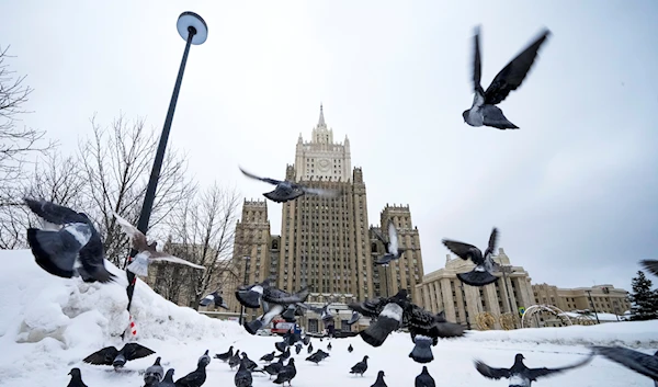 Pigeons take off in front of the Russian Foreign Ministry building in Moscow, Russia, Wednesday, Jan. 26, 2022 (AP Photo/Alexander Zemlianichenko)