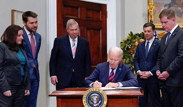 President Joe Biden signs H.J.Res.100, a bill that aims to avert a freight rail strike, in the Roosevelt Room at the White House, Friday, Dec. 2, 2022, in Washington. (AP)