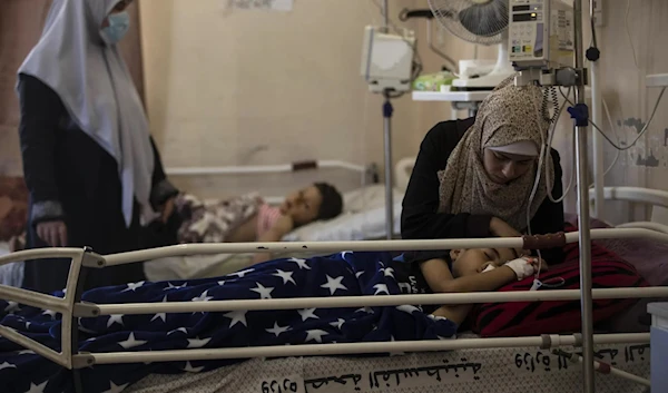 A mother comforts her child who was wounded by an Israeli airstrike, May 13, 2021, Gaza, Palestine. (AP)