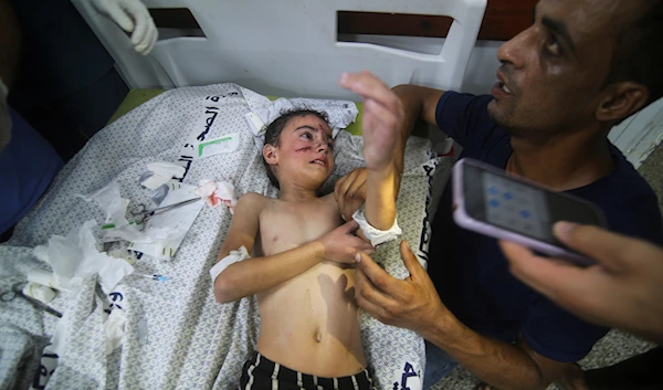 A Palestinian child wounded in Israeli bombardment waits for treatment in a hospital in Rafah refugee camp, southern Gaza Strip, October 12, 2023 (AP)