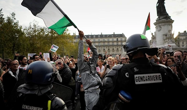 A protestor holds a Palestinian flag during a rally in solidarity with the Palestinian people in Gaza, in Paris, Thursday, Oct.12, 2023 (AP Photo/Thibault Camus)