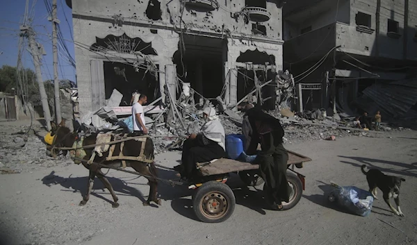 Palestinians leaving their homes after Israeli airstrikes in Rafah refugee camp, southern Gaza Strip, on October 12, 2023. (AP)