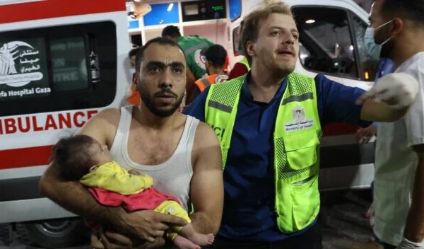 A man transports an injured Palestinian baby into Al-Shifa hospital in Gaza City following a brutal Israeli airstrike on October 11, 2023. (AFP)