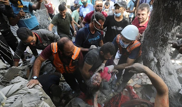 Palestinians rescue a child from under the rubble after Israeli airstrikes in Gaza City, occupied Palestine, October 18, 2023 (AP)