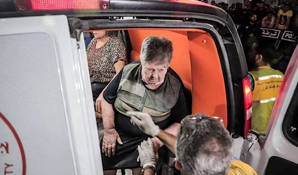 An old lady is being escorted in an ambulance after suffering from injuries during the Israeli target on the Church.