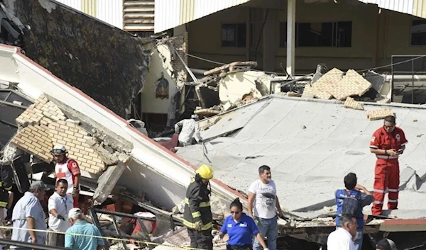 rescue workers search for survivors amid debris after the roof of a church collapsed during a Sunday mass