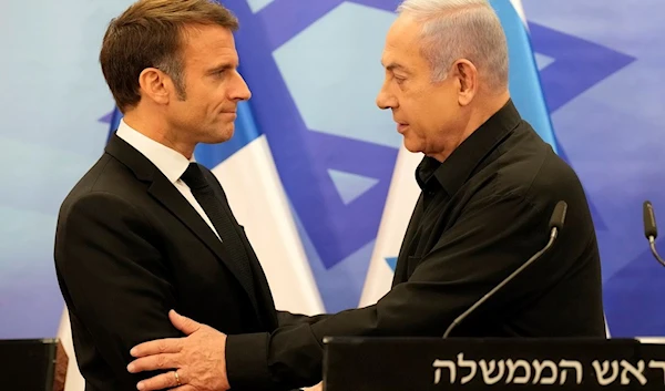 Israeli Prime Minister Benjamin Netanyahu, right, shakes hands with French President Emmanuel Macron after a joint press conference in Occupied Al-Quds, Tuesday, Oct. 24 (AP)