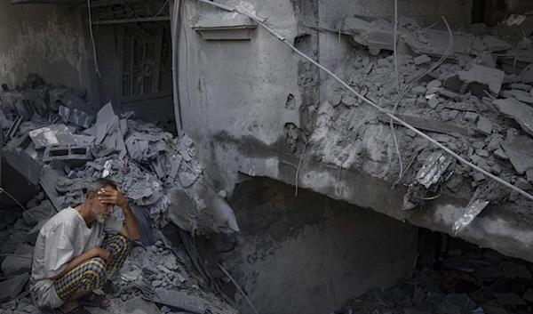 A Palestinian man talks on the phone by the buildings destroyed in the Israeli bombardment of the Gaza Strip in Rafah on October 22, 2023. (AP)