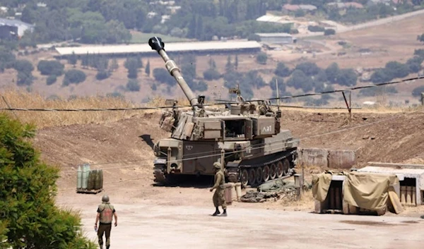 Israeli occupation forces stand near an army self-propelled artillery vehicle on the outskirts of  "Kiryat Shmona" on July 6, 2023. (AFP)