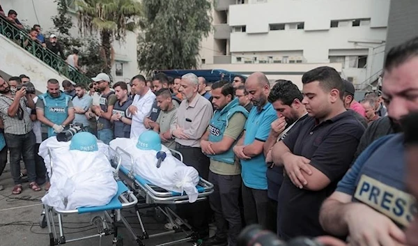 Mourners attend the funeral of fellow journalists Said al-Taweel and Mohammed Sobboh who were killed in an Israeli airstrike on Gaza City on October 10, 2023. (AFP)