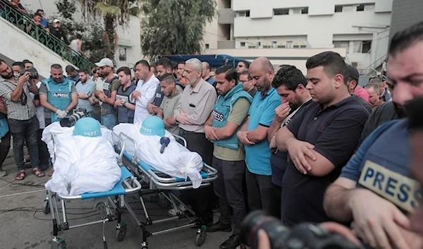 Mourners attend the funeral of fellow journalists Said al-Taweel and Mohammed Sobboh who were killed in an Israeli airstrike on Gaza City on October 10, 2023. (AFP)