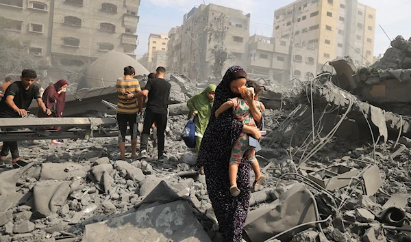 Palestinians in Gaza city inspect the damage following an Israeli airstrike, 9 October 2023. (AFP)