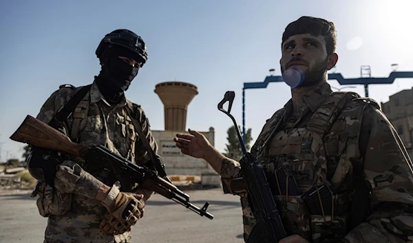 US-backed Syrian Democratic Forces (SDF) fighters stand guard on a street at al-Baseera town, in the eastern countryside of Deir Ezzor, Syria, Sept. 4, 2023 (AP)