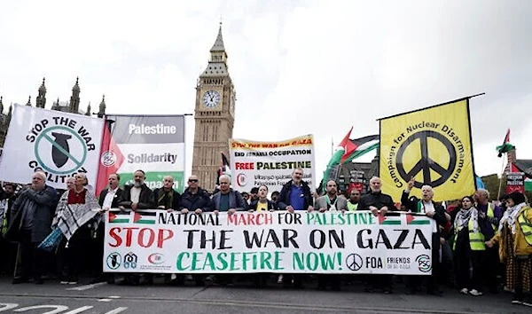 Protesters hold a banner during a pro-Palestinian march, in central London, October 28, 2023. (AP)