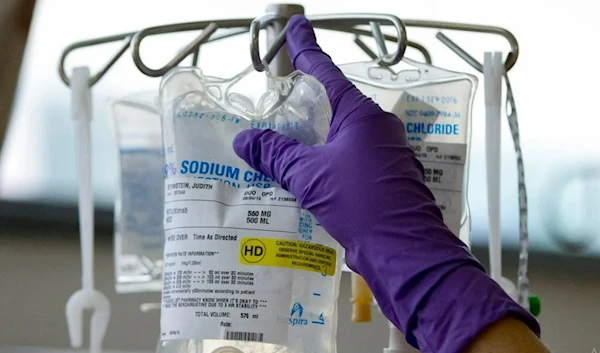 A nurse places a patient's chemotherapy medication on an intravenous stand. (AP)