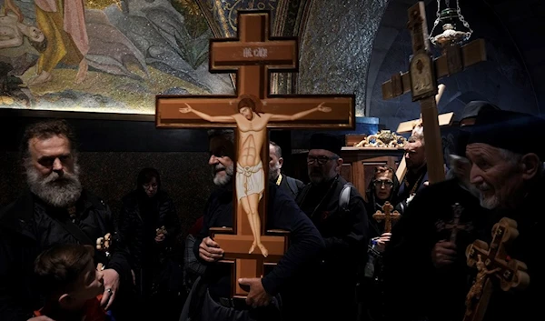 Orthodox Christian worshippers carry crosses during the Good Friday procession at the Church of the Holy Sepulcher, where many Christians believe Jesus was crucified, buried and rose from the dead, in Jerusalem's Old City, Friday, April 14, 2023. (AP)