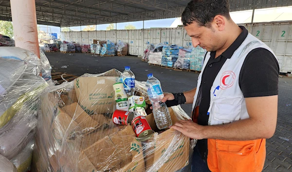 United Nations and Red Crescent workers prepare the aid for distribution to Palestinians at UNRWA warehouse in Deir Al-Balah, Gaza Strip, on Monday, Oct. 23, 2023. (AP)