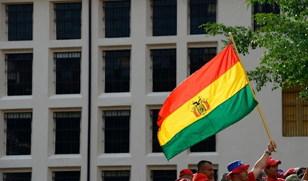 A pro-government supporter waves a Bolivian national flag during a rally in Caracas, Venezuela, Saturday, Nov. 16, 2019.  (AP)