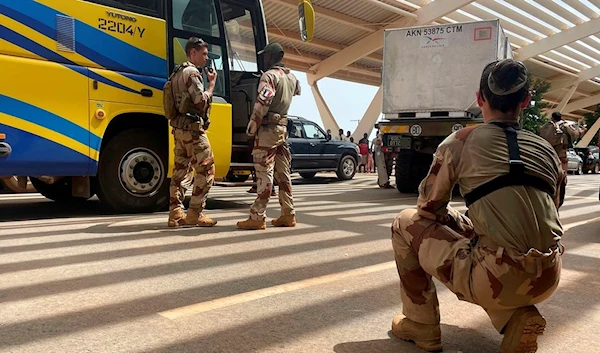 French soldiers assist French nationals on a bus waiting to be airlifted back to France on a French military aircraft, at the International Airport in Niamey, Niger, Tuesday, Aug. 1, 2023 (AP)