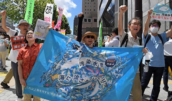 Protesters hold a banner which reads "No dumping radioactive water into the ocean" during a rally in front of the TEPCO headquarters on Aug 24, 2023, in Tokyo, Japan (AP)