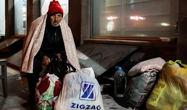 An ethnic Armenian man from Nagorno-Karabakh sits near a tent camp after arriving to Armenia's Goris in Syunik region, Armenia, late Friday, Sept. 29, 2023.