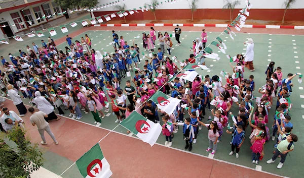 Schoolchildren wait in line in a school courtyard in in the Ben Omar district of Algiers, Algeria, on Sept.19, 2023 (AP)