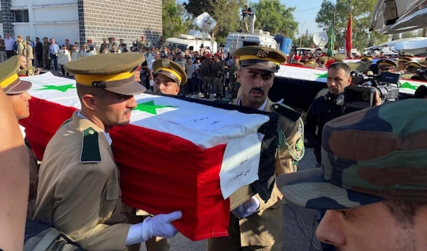 Syrian student officers carry the coffins of a victim who were killed on Thursday in a drone attack that hit a military graduation ceremony, during a mass funeral procession in Homs, Syria, Friday, Oct. 6, 2023. (AP)