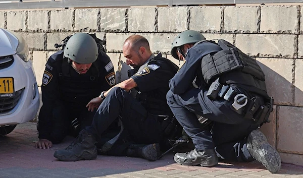 Israeli police ducking for cover in "Ashkelon" streets amid blaring sirens, October 7, 2023. (AFP)