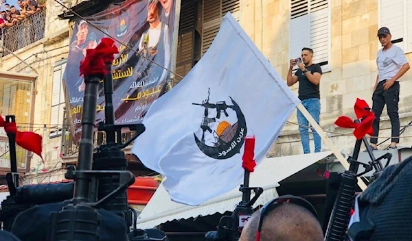 The flag of the Lions’ Den is held during a funeral procession for two of its martyrs -undated picture- (social media)