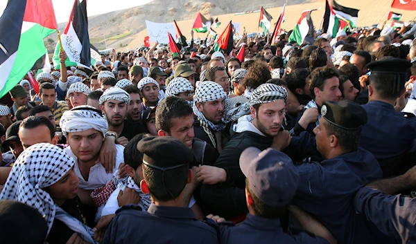 Pro-Palestinian demonstrators clash with Jordanian police as they block their rally from reaching the Israeli border, in Southern Souneh, Jordan Sunday, May 15, 2011. (AP)