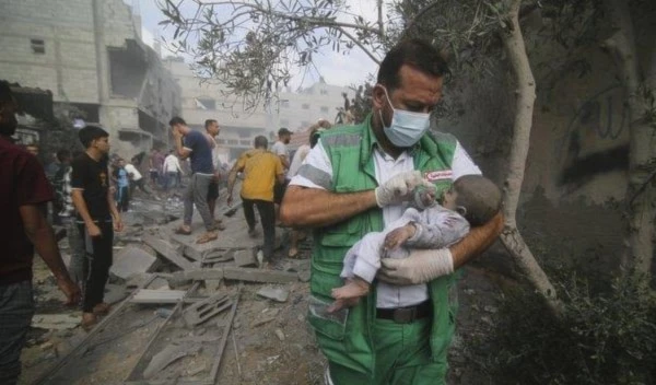 Palestinian medic takes a baby pulled out of buildings destroyed in the Israeli bombardment of the Gaza Strip in Rafah, Sunday, Oct. 22, 2023. (AP