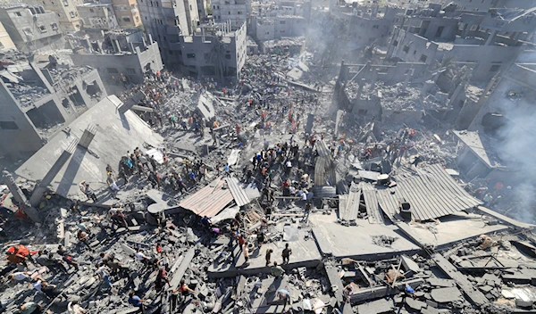 People search for survivors and for bodies of victims through the rubble of buildings destroyed during Israeli airstrikes, in Khan Yunis in the southern Gaza Strip, October 26, 2023, amid the Israeli genocide in Gaza. (AFP)