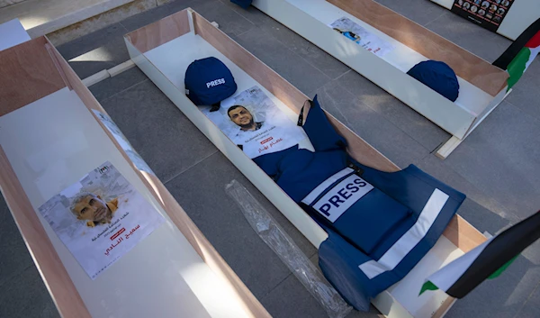 Posters with names and pictures of Sameeh Nadi, left and Esam Bashar,placed in mock coffins of Palestinian journalists who were killed, in the West Bank city of Ramallah, Nov. 7, 2023.  (AP)