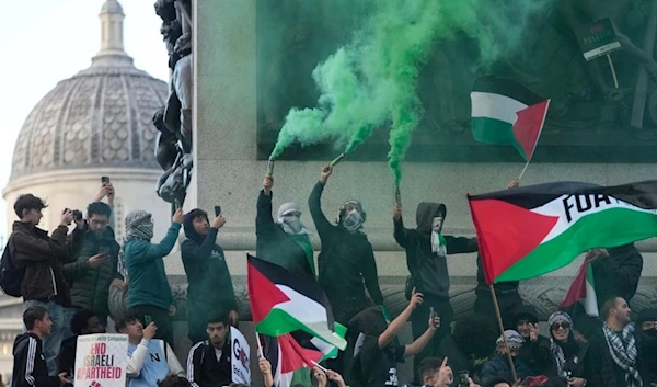 Protesters hold flares during a pro Palestinian demonstration in London, Saturday, Oct. 14, 2023. (AP)