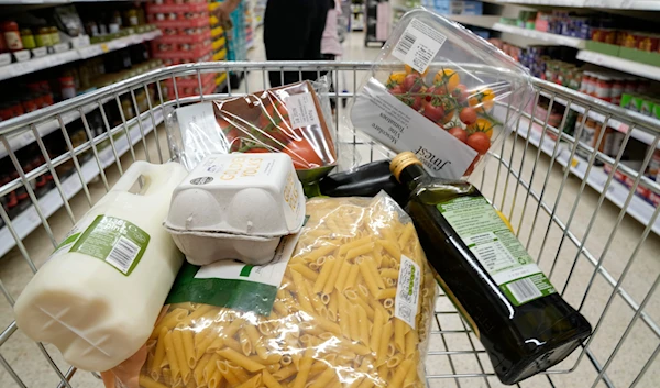 A basket of groceries a trolly at a supermarket in London, Saturday, June 10, 2023. (AP)