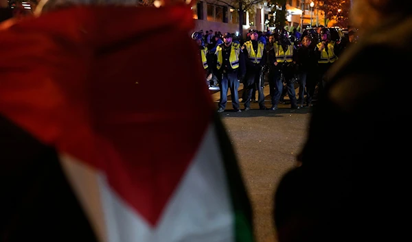 Candles lit by protesters line the street as U.S. Capitol Police officers stand outside the headquarters of the Democratic National Committee Wednesday, Nov. 15, 2023, in Washington. (AP)