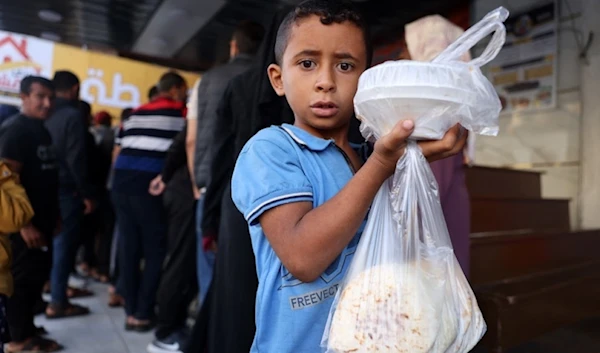 Food, water in Gaza 'practically non-exA boy returns home with bags of food in Rafah in the southern Gaza Strip on October 20, 2023. (AFP)istent' in Gaza: UN WFP