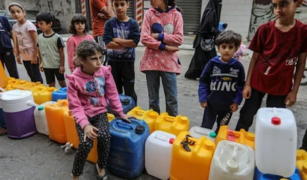 Palestinian children fill containers with unsafe water in Rafah, in the southern Gaza Strip on November 13, 2023, amid the ongoing Israeli aggression and blockade on Gaza. (AFP via Getty Images)