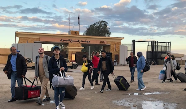 Palestinians with European passports who were evacuated from Gaza sit cross the Rafah border crossing in Egypt Wednesday, Nov. 15, 2023 (AP)