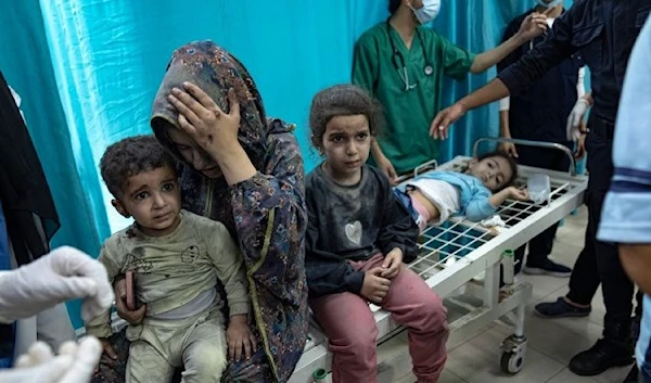 Palestinian mother and her children wounded in Israeli bombardment of the Gaza Strip are brought to a hospital in northern Gaza (AP)