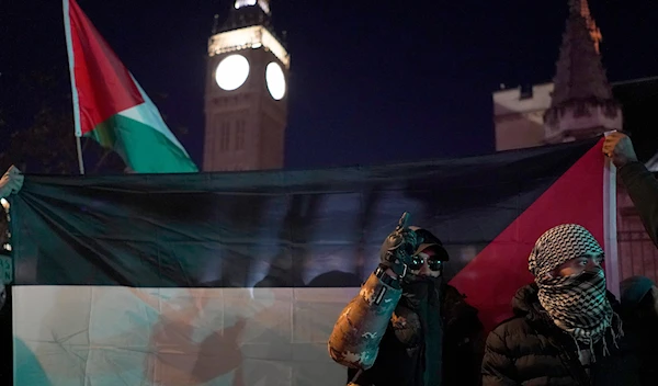 Protesters show flags during a pro-Palestinian protest in front of the Houses of Parliament in London, Wednesday, Nov. 15, 2023. (AP)