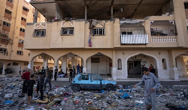 Palestinians look at destruction after an Israeli strike on the Gaza Strip in Khan Younis, Saturday, Nov. 18, 2023 (AP Photo/Fatima Shbair)