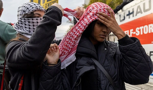 Two people use a Palestinian keffiyeh to show their support during a Pro-Palestinian demonstration in Washington on Saturday, Nov. 4, 2023 (AP)