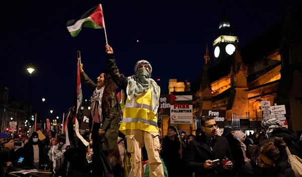 Protesters wave flags during a pro-Palestinian protest in front of the Houses of Parliament in London on Nov. 15, 2023. (AP)