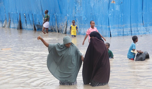 Somali women walk through floodwater during heavy rains in Mogadishu, Somali, Monday, Nov. 20, 2023. (AP)